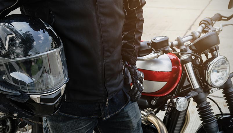 Motorcycle Insurance Laws in Colorado require helmet for riders under 18 like shown in the photos of rider holding helmet with eye protection.